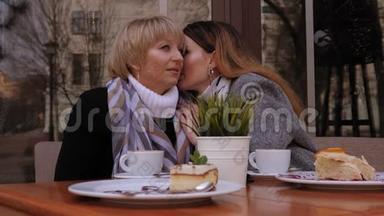 一位<strong>年迈</strong>的<strong>母亲</strong>和一位成年的女儿正在一家街头咖啡馆里交谈。 八卦。